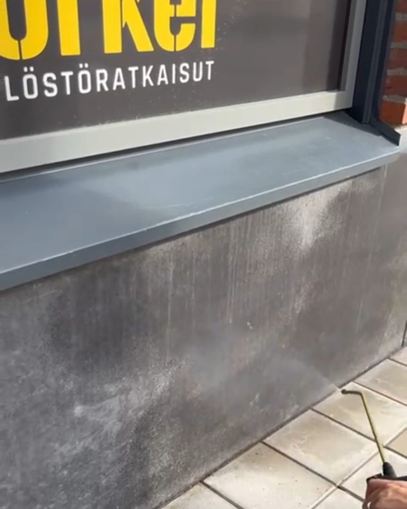 Graffitinsuojan levitys kiviseinään liikehuoneiston julkisivussa