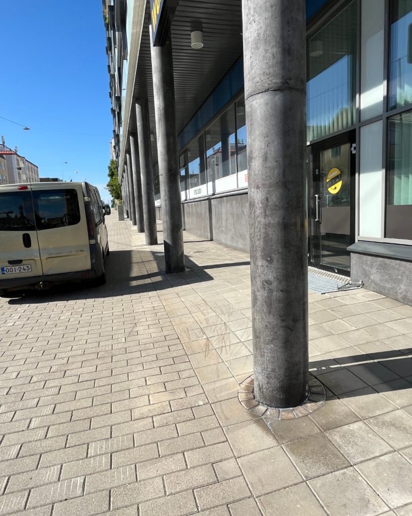 Applicering av graffitiskydd på en stenmur på fasaden till ett bostadsbolag