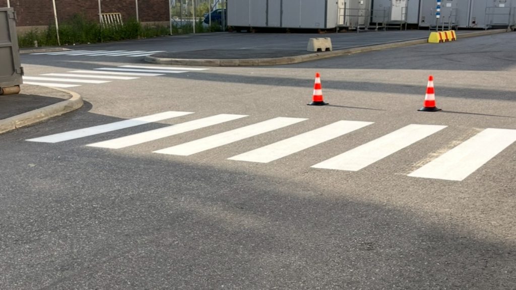 Målning av vindskyddet på parkeringsplatsen - tydliga och korrekta vägmarkeringar